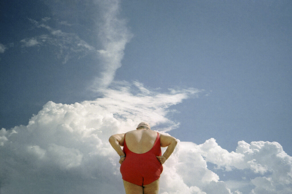 lady with red swimsuit and blue sky with clouds