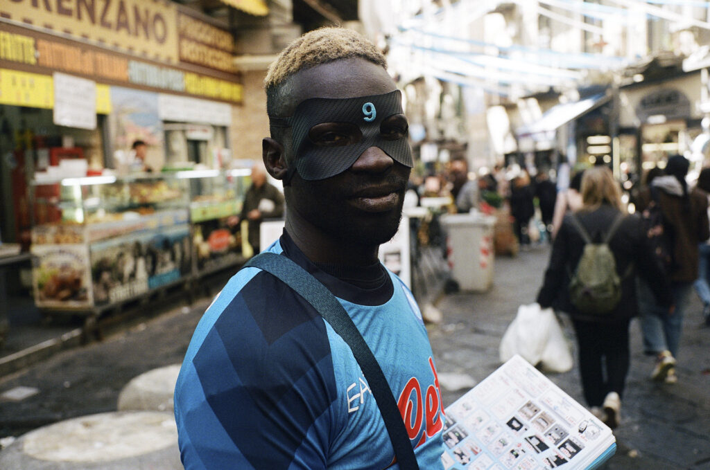 closeup of a man with black face mask with number 9 in blue