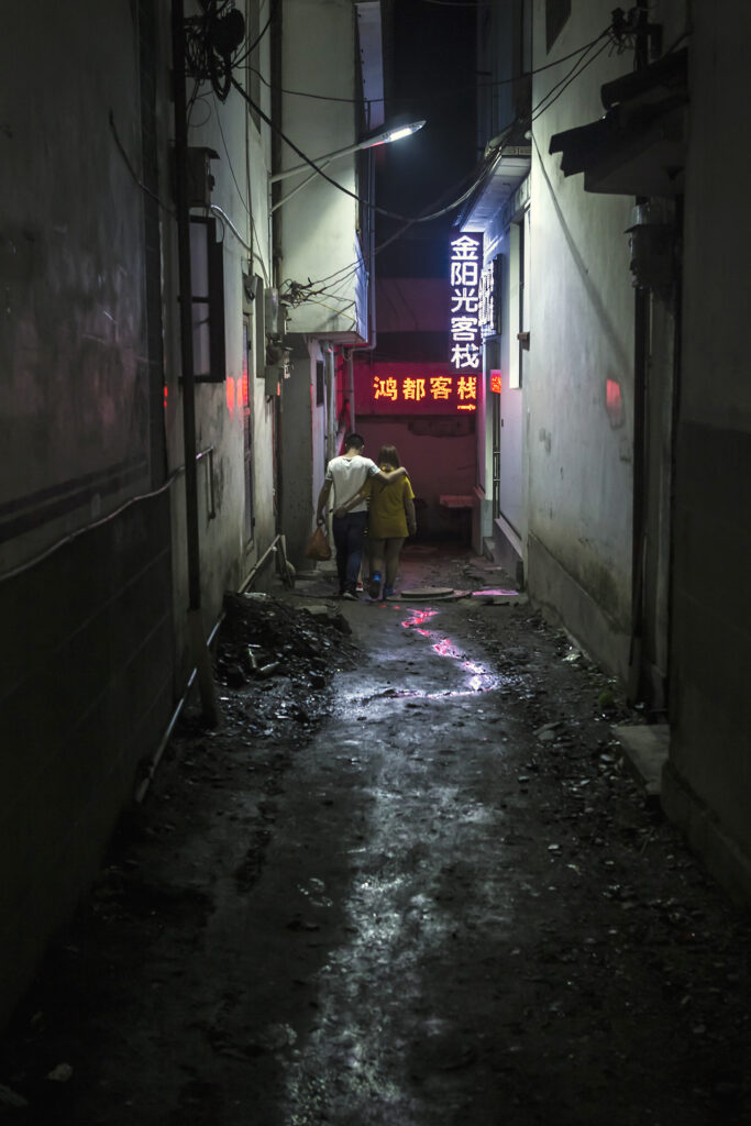 pareja andando abrazados en una callejuela de noche