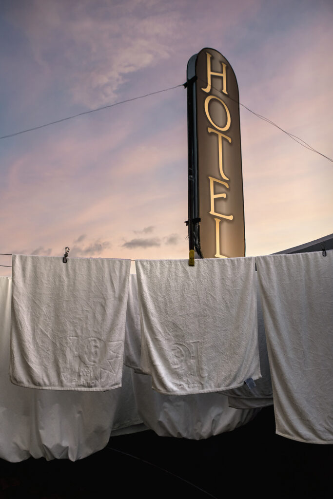 billboard writing Hotel in vertical with white clothes hanging in front