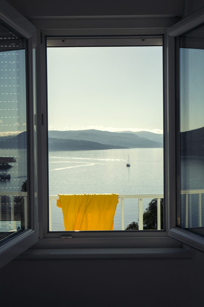 yellow t-shirt hanging on a balcony of a hotel in front of the sea