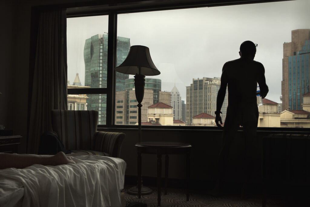 man in front of a window in a backlit hotel room