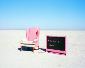 pink armchair and television abandoned in the desert